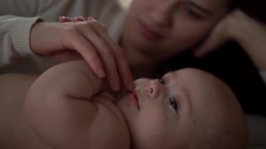 Genç annesi olan yeni doğmuş bir bebek birbirlerinin gözlerinin içine bakar. Şirin Gülümseyen Dişsiz Çocuk Yüzlü Portresi. Çocuklu Öpüşen Kadın kameraya bak. Bebek, Anneler Günü, Doğum, Başlangıç, İlişki Konsepti