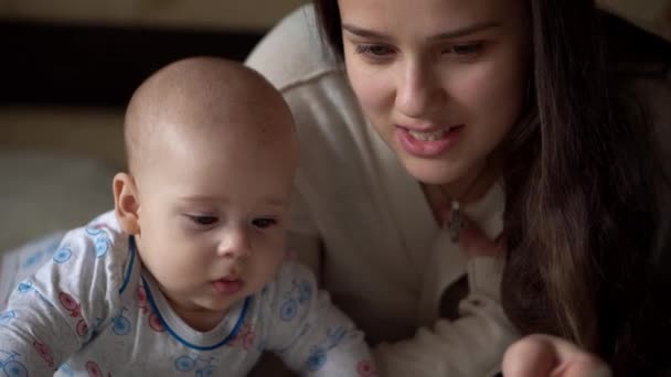 Neugeborenes aktives Baby mit junger Mutter Niedliches Lächeln Zähneloses Gesicht Portrait Early Days On Magenentwicklung Neck Control. Frau mit Kind blickt auf Kamera Reed Book. Säugling, Geburt, Beginnkonzept — Stockvideo