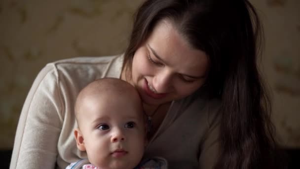 Nyfödd Aktiv bebis med ung mamma. Söta leende Teethless ansikte porträtt tidiga dagar på mage utveckla hals kontroll. Mamma kysser med barn titta på kameran. Spädbarn, förlossning, Begynnelsebegreppet — Stockvideo