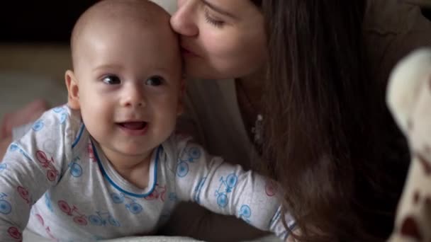 Újszülött Aktív Baba Fiatal Anyával. Aranyos gyerek mosolygós fogatlan arc portré korai napokban a gyomorban fejlődő nyaki kontroll. Anya és Gyermek Nézd a kamerát Játssz játékkal. Csecsemő, kezdő koncepció — Stock videók