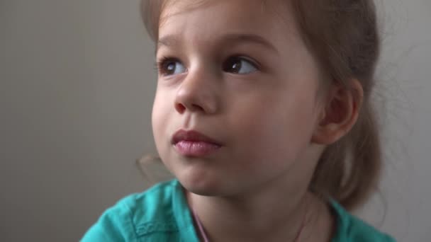 Портрет Смішна маленька крупним планом щаслива дівчинка дошкільного віку, усміхнена дитина, дивлячись в очі вдумливо, досить природне обличчя. — стокове відео