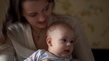 Genç annesi olan yeni doğmuş aktif bir bebek. Sevimli Çocuk Dişsiz Yüzü Portresi Mide Gelişen Boyun Kontrolü İlk Günleri. Anne ve Çocuk, oyuncak ile kamera oyununa bakın. Bebek, Başlangıç Konsepti