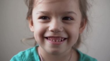 Portre Komik Mutlu küçük çocuk mutlu anaokulu kızı kameraya bakarak gülümsüyor güzel doğal yüz. Samimi duygular utanç verici, utanç verici cilt dermatolojisi, pediatrik dişçilik