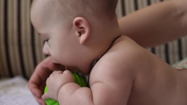 Οικογένεια, παιδική ηλικία. Κοντινό πλάνο Happy baby baby with Teething Toy. Γυμνό μικρό παιδί σε πάνα παίζει πράσινο καουτσούκ μπάλα Roll πάνω στο στομάχι στο σπίτι. Νεογνό παιδί Υγείας μασάζ ιατρικής — Αρχείο Βίντεο
