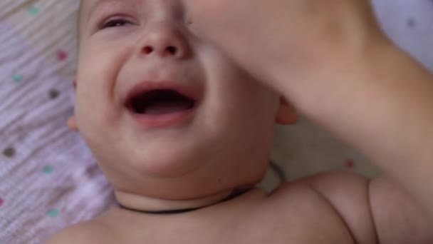 Βρεφική ηλικία, παιδική ηλικία, μητρότητα, υγιεινή, ιατρική και υγεία έννοια - γυναικεία moms χέρι σκουπίζει το σώμα του νεογέννητου γυμνού μωρού με βαμβάκι μαξιλάρι που βρίσκεται σε πάνα στην πλάτη με ομφαλό σφιγμένο από ιατρικό κλιπ — Αρχείο Βίντεο