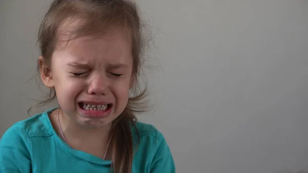 Portrait little girl sad upset child burst into tears cries sob looking at camera indoors. sincere children emotions feelings at home crying kid with pretty face. Concept childhood insult offend grief — Stock Photo, Image