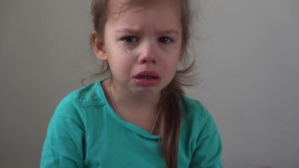 Retrato niña triste niño molesto estalló en lágrimas llora sollozo mirando a la cámara en el interior. niños sinceros emociones sentimientos en casa llorando niño con cara bonita. Concepto insulto de la infancia ofender el dolor — Vídeo de stock