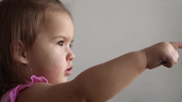 Small Toddler girl making funny expressive grimace face with soft Toy Bear at home. Childhood emotions feelings sadness happiness. naughty capricious child. Close up kid looking out point to window — Stock Video