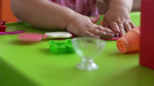 儿童雕塑和粘土模型。2-5岁的女孩用手指和塑料造型刀来塑造粉红的面团。利用游戏黏土提高儿童的运动技巧和创造力 — 图库视频影像