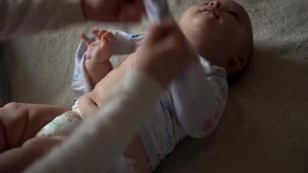 Bebé recién nacido y mamá joven yacen en la cama. Lindo retrato de cara de niño sin dientes sonriente. Mujer con niño quitado traje de cuerpo. Mamá cuida de Babe. Bebés, Día de la Madre, Parto, Principio, Concepto de Relación — Vídeos de Stock