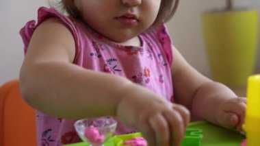 Çocuklar için heykel ve kil modelleme. 2-5 yaşlarındaki kız pembe oyun hamurunu parmaklarıyla ve plastik maket bıçağıyla şekillendiriyor. Oyun kilini kullanarak iyi motor becerileri ve çocuk yaratıcılığını geliştirmek.