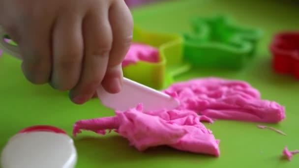 Bildhauerei und Modellierung aus Ton für Kinder. Mädchen im Alter von 2-5 Jahren formen und formen rosa Spielteig mit Fingern und Modelliermesser aus Kunststoff. Feinmotorik und Kreativität der Kinder mit Spielknete fördern — Stockvideo