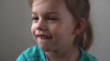 Portre Komik küçük yakın çekim mutlu anaokulu kızı düşünceli, oldukça doğal yüzünü çeviren çocuk utangaç, utangaç, temiz cilt dermatolojisi, pediatrik