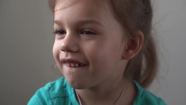 Portre Komik küçük yakın çekim mutlu anaokulu kızı düşünceli, oldukça doğal yüzünü çeviren çocuk utangaç, utangaç, temiz cilt dermatolojisi, pediatrik — Stok video