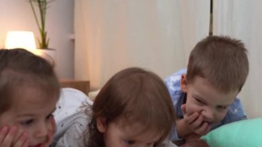 Gülen Anaokulu Bebeği Pijamalı Çocuklar Yatakta Akıllı Telefon 'da çizgi film izliyor. Kardeşler Küçük İkiz Oğlan ve Kız Eğleniyor. Evde karantinada mutlu çocuklar. Arkadaşlık, Aile, Eğitim
