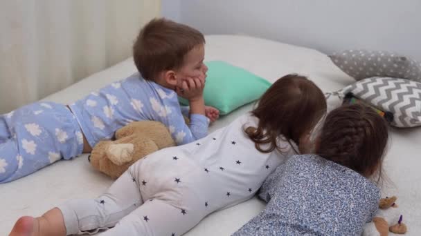 Uśmiechnięty przedszkolak Dzieci w piżamie oglądanie kreskówek na smartfonie na łóżku. Rodzeństwo Little Twins Boy and Girl Have Fun. Szczęśliwe dzieci na kwarantannie w domu. Przyjaźń, Rodzina, Edukacja — Wideo stockowe
