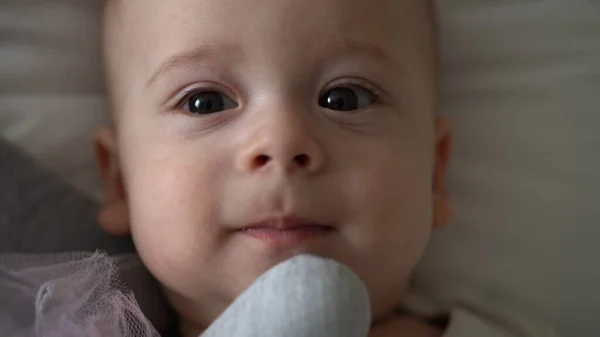 Κοντινό πλάνο Ευτυχισμένο παιχνιδιάρικο παιδί 6 μηνών. Νεογνό αγόρι κοιτάζει κάμερα μετά το μπάνιο ντους σε λευκό μαλακό κρεβάτι. το μωρό ξυπνάει πριν κοιμηθεί με τον Τόι. Παιδική ηλικία, μητρότητα, οικογένεια, νήπιο — Φωτογραφία Αρχείου