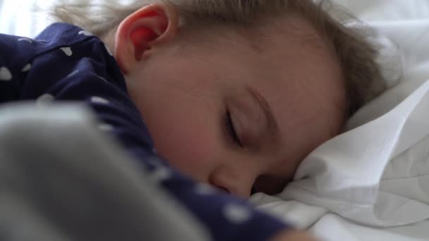 Autentyczne Cute Little Girl Śpiąca Słodko W Wygodne Białe I Szare Łóżko Zbliżenie. Piękne Zmęczone Dziecko Mają Czas Odpoczynku Delikatnie Kojące. Dzieciak w łóżeczku. Opieka, Dzieciństwo, Rodzicielstwo, Pojęcie życia — Wideo stockowe