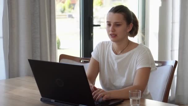 Autentyczna biała młoda kobieta rozmawiająca na laptopie w salonie. Pisanie wyszukiwania za pomocą IT w recepcji. Happy Lady pracuje nad komputerowym przeglądaniem Internetu. Buisenes, Edukacja, Koncepcja technologii — Wideo stockowe