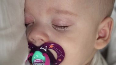 Dikey yakın plan, yeni doğmuş tombul bebek karın üstü uzanmış, gözleri açık ve beyaz arka planda battaniyeye sarılmış bir şekilde gülümsüyor. bebeklik, çocukluk, gelişme, tıp ve sağlık konsepti.