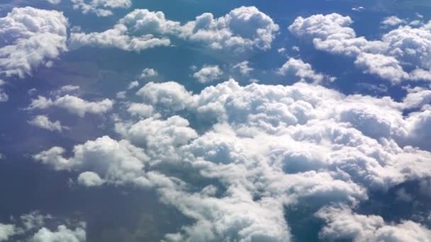 Uçak penceresinden kanada bak. Dışarıda hava güzel. Gökyüzündeki bulutlar. Uçağın lombozundan yere doğru bak. Gökyüzündeki bulutların üzerinde uçuyor. Yolcu dışarı bakar. — Stok video