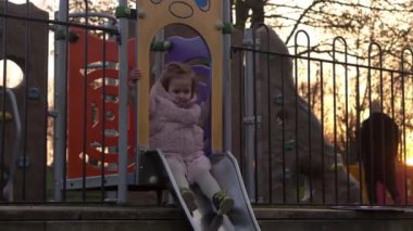 Üç küçük mutlu çocuk kayarak eğleniyor. Gülen Komik Kardeşler 'in arkadaşları dışarıda oynuyor. Duygusal çocuklar parktaki çocuk parkında atlı karıncaya biniyorlar. Mutlu aile, çocukluk, arkadaşlık.