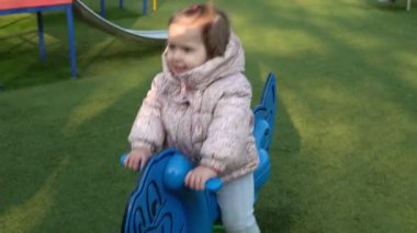 Dışarıda salıncakta sallanırken eğlenen orta sınıf bir kardeş çocuk portresi. Çocuk parktaki çocuk parkında oynarken kameraya gülümsüyor. Mutlu aile, çocukluk.
