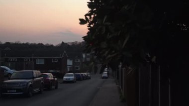 Gün batımında mutlu bir aile. Bir grup insanın silueti parkta yürüyor. Ailesi el ele tutuşan mutlu bir çocuk. Aile çimlerin üzerinde parkta yürümektir. Mutlu aile kavramı. Ebeveynler çocuklarının elini tutarlar.