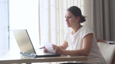 Oturma odasında dizüstü bilgisayarda sohbet eden otantik beyaz kadın. Masada aratarak yazma. Bilgisayar taraması yapan mutlu bayan. Buisenes, Eğitim, Teknoloji Konsepti