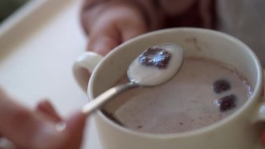 Kapalı tabak gevrekleri ve sütlü anne beyazı yüksek sandalyeyle besliyor, çocuk kendini yemeye çalışıyor, yemek lekeli çocuk, kaşıkla yulaf lapası yiyen küçük kız. Süt ürünleri