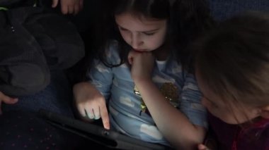 Otantik 3 küçük anaokulu çocuğu reşit olmayan çocuk kardeşler çizgi film izleyip akıllı telefon aygıtı bilgisayarında sohbet ediyorlar. Aile, çocukluk, arkadaşlık