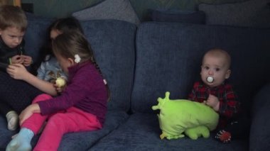 Otantik 3 küçük anaokulu çocuğu reşit olmayan çocuk kardeşler çizgi film izleyip akıllı telefon aygıtı bilgisayarında sohbet ediyorlar. Aile, çocukluk, arkadaşlık