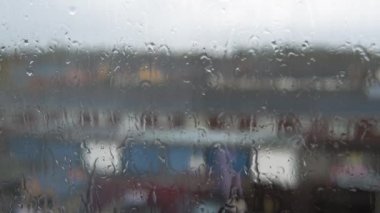 Muson mevsiminde pencere camına yağmur damlaları düşer. Su Damlaları Bulanık Doğa Arkaplanından Akıyor, Statik Çekim. Dışarısı çok kötü. Sonbahar ya da Bahar Yağmurlu Gün Sağanağı. Depresyon, Melankoli Kavramı