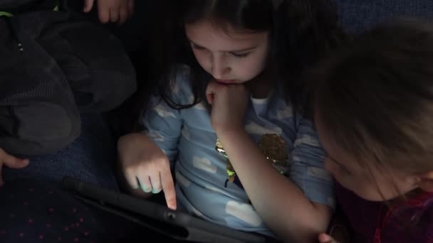 Auténticos niños pequeños preescolares de 3 niños pequeños hermanos ven dibujos animados jugando juegos en línea chating en la tableta del ordenador portátil del dispositivo del teléfono inteligente juntos en casa dentro. Familia, infancia, amistad — Vídeos de Stock