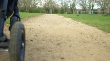 Sonbahar ya da ilkbaharda yapraklar ve su birikintileri üzerinde giden bebek arabasının tekerleklerinin düşük görüntüsü. Nakliye kamyonu Macro. Park Trail 'de aile yürüyüşü. Bebekler, Ebeveynlik, Ulaşım Konsepti