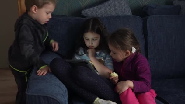 Autentiska 3 små förskola småbarn barn syskon titta på tecknad spela spel online chatta på smartphone enhet bärbar dator tablett tillsammans hemma inomhus. Familj, barndom, vänskap — Stockvideo