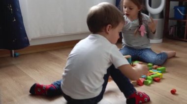 Oyun Salonundaki İki Mutlu Anaokulu Kardeşleri Çocuk Kız Çocuğu. Ev inşaatında aynı yaştaki çocuklar tahta oyuncaklarla oynarlar. Bebek evde çok zaman geçirdi. Çocukluk, Ebeveynlik, Arkadaşlık Konsepti