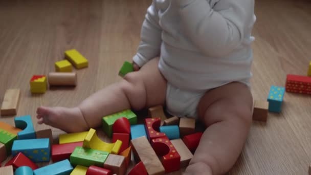 Ευτυχισμένο νεογέννητο μωρό στο δωμάτιο παιχνιδιού. Το βρέφος παίζει με ξύλινα παιχνίδια στο σπίτι Κατασκευές Κατασκευές από γεωμετρικά σχήματα. Παιδί έχουν περάσει χρόνο κατά τη διάρκεια του παιχνιδιού Motor Skills. Παιδική ηλικία, έννοια της πατρότητας — Αρχείο Βίντεο