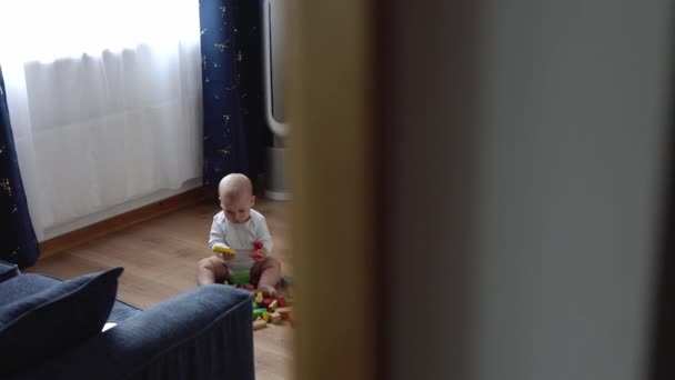 Gelukkige pasgeboren baby in de speelkamer. Baby Kid spelen met houten speelgoed thuis bouwen Constructies van geometrische figuren. Kind hebben besteed tijd tijdens Motor Skills Game. Jeugd, Ouderschap Concept — Stockvideo