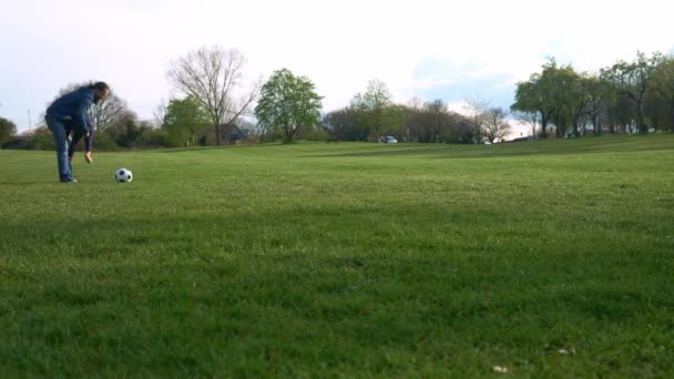 Vader en kleine zoon jongleren met zwarte en witte klassieke voetbal bal. Mensen gaan naar de sportschool. Jonge jongen die voetbal speelt. Happy Family Team hebben tijd doorgebracht in het park. Gezond leven, kampioenschap.. — Stockvideo