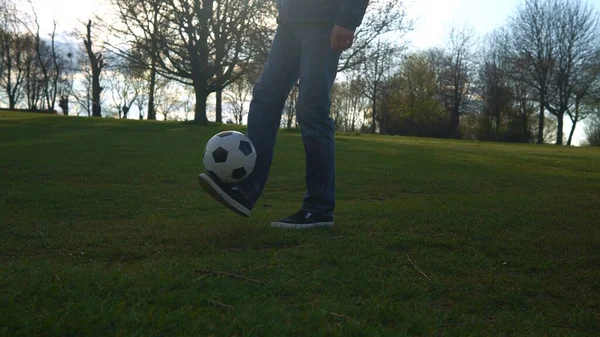 Man In Blue Jeans And Moccasins Juggling Black and White Classic Soccer Ball. People Go In For Sports. Young Boy Playing Football. Happy Family Team Have Spend Time At Park. Healthy Life, Championship — Stock Photo, Image