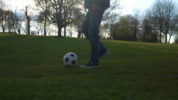 Man in blauwe jeans en sporadisch jongleren met zwart-wit klassieke voetbal bal. Mensen gaan naar de sportschool. Jonge jongen die voetbal speelt. Happy Family Team hebben tijd doorgebracht in het park. Gezond leven, kampioenschap — Stockvideo