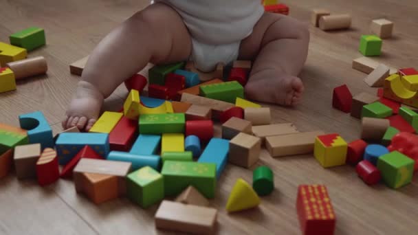 Glad nyfödd baby i lekrummet. Spädbarn barn leka med träleksaker hemma bygga konstruktioner från geometriska figurer. Barn har tillbringat tid under Motor Skills Game. Barndom, föräldrakoncept — Stockvideo