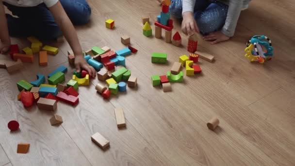 Dois irmãos pré-escolares felizes crianças menino menina em sala de jogos. Crianças da mesma idade jogar com brinquedos de madeira em casa construir construção. Bebê passou o tempo em casa. Infância, Paternidade, Conceito de Amizade — Vídeo de Stock