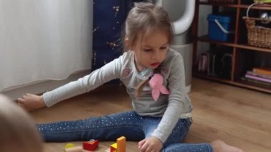 Oyun Salonundaki İki Mutlu Anaokulu Kardeşleri Çocuk Kız Çocuğu. Ev inşaatında aynı yaştaki çocuklar tahta oyuncaklarla oynarlar. Bebek evde çok zaman geçirdi. Çocukluk, Ebeveynlik, Arkadaşlık Konsepti