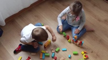 Oyun Salonundaki İki Mutlu Anaokulu Kardeşleri Çocuk Kız Çocuğu. Ev inşaatında aynı yaştaki çocuklar tahta oyuncaklarla oynarlar. Bebek evde çok zaman geçirdi. Çocukluk, Ebeveynlik, Arkadaşlık Konsepti
