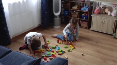 Oyun Salonundaki İki Mutlu Anaokulu Kardeşleri Çocuk Kız Çocuğu. Ev inşaatında aynı yaştaki çocuklar tahta oyuncaklarla oynarlar. Bebek evde çok zaman geçirdi. Çocukluk, Ebeveynlik, Arkadaşlık Konsepti