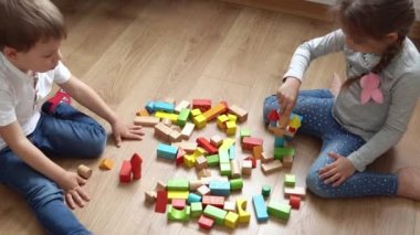 Oyun Salonundaki İki Mutlu Anaokulu Kardeşleri Çocuk Kız Çocuğu. Ev inşaatında aynı yaştaki çocuklar tahta oyuncaklarla oynarlar. Bebek evde çok zaman geçirdi. Çocukluk, Ebeveynlik, Arkadaşlık Konsepti