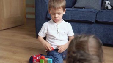 Oyun Salonundaki İki Mutlu Anaokulu Kardeşleri Çocuk Kız Çocuğu. Ev inşaatında aynı yaştaki çocuklar tahta oyuncaklarla oynarlar. Bebek evde çok zaman geçirdi. Çocukluk, Ebeveynlik, Arkadaşlık Konsepti