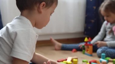 Oyun Salonundaki İki Mutlu Anaokulu Kardeşleri Çocuk Kız Çocuğu. Ev inşaatında aynı yaştaki çocuklar tahta oyuncaklarla oynarlar. Bebek evde çok zaman geçirdi. Çocukluk, Ebeveynlik, Arkadaşlık Konsepti